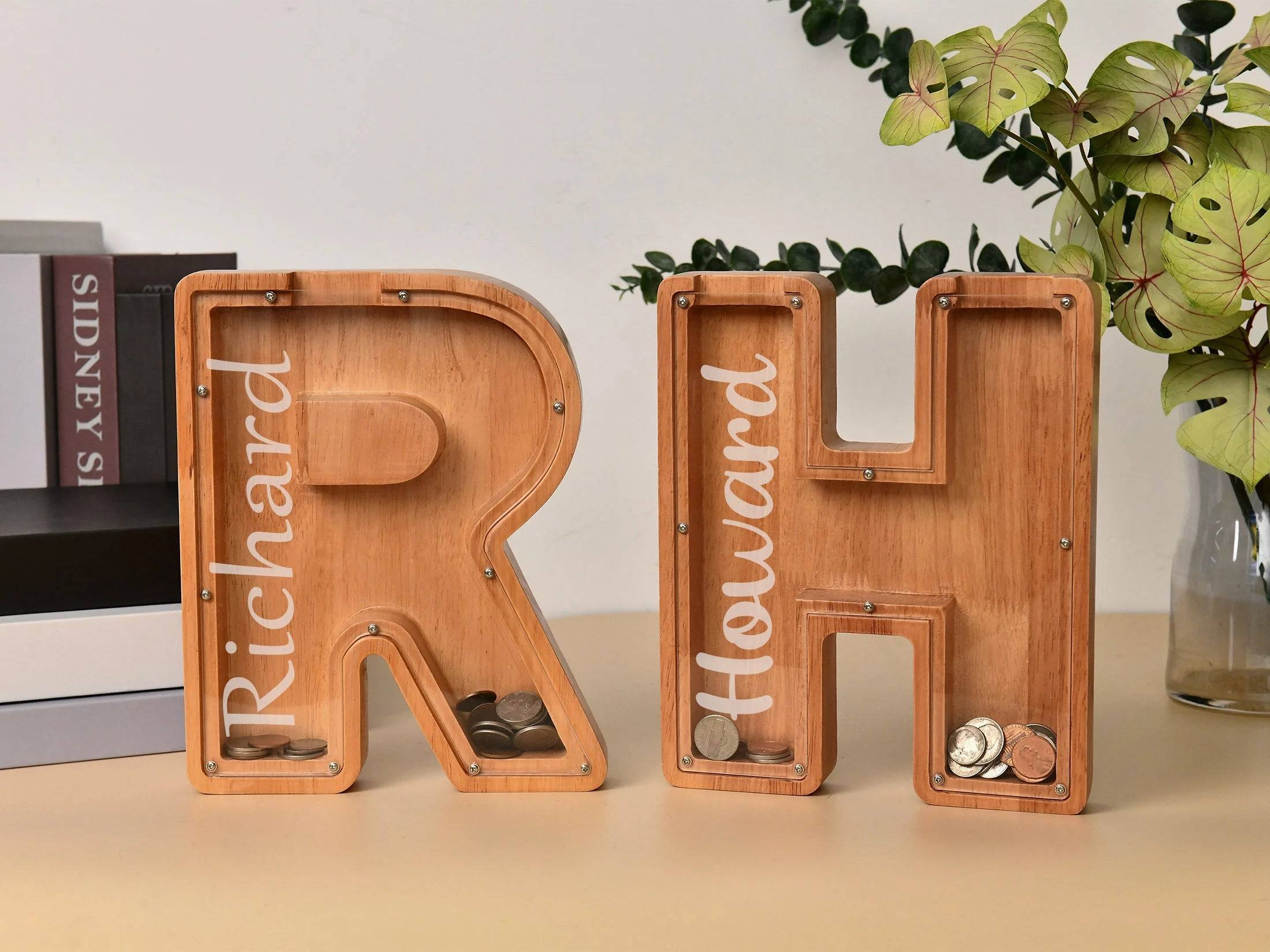 Custom wooden letter piggy banks 'R' and 'H' for teaching kids about savings and money management.